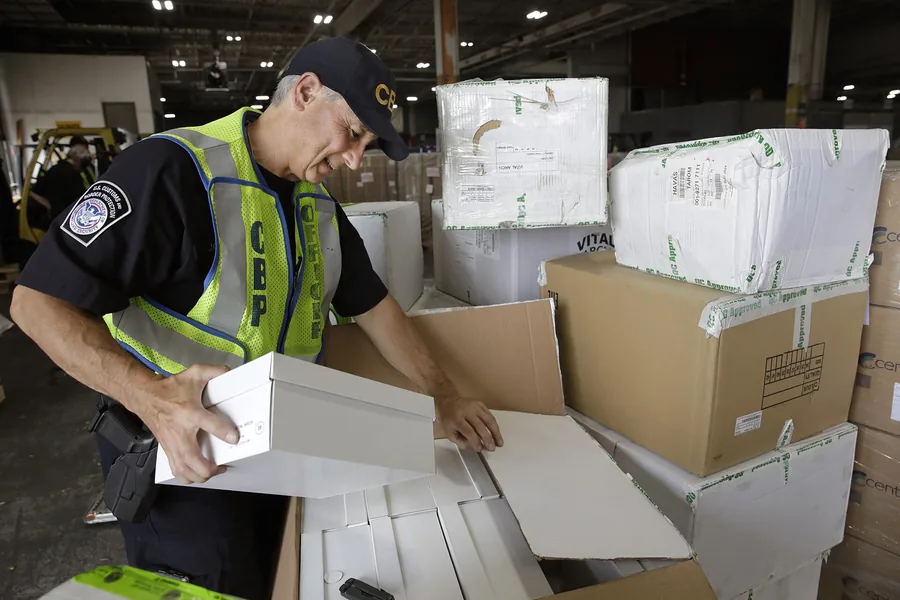 Customs officer inspecting international packages in an air cargo warehouse